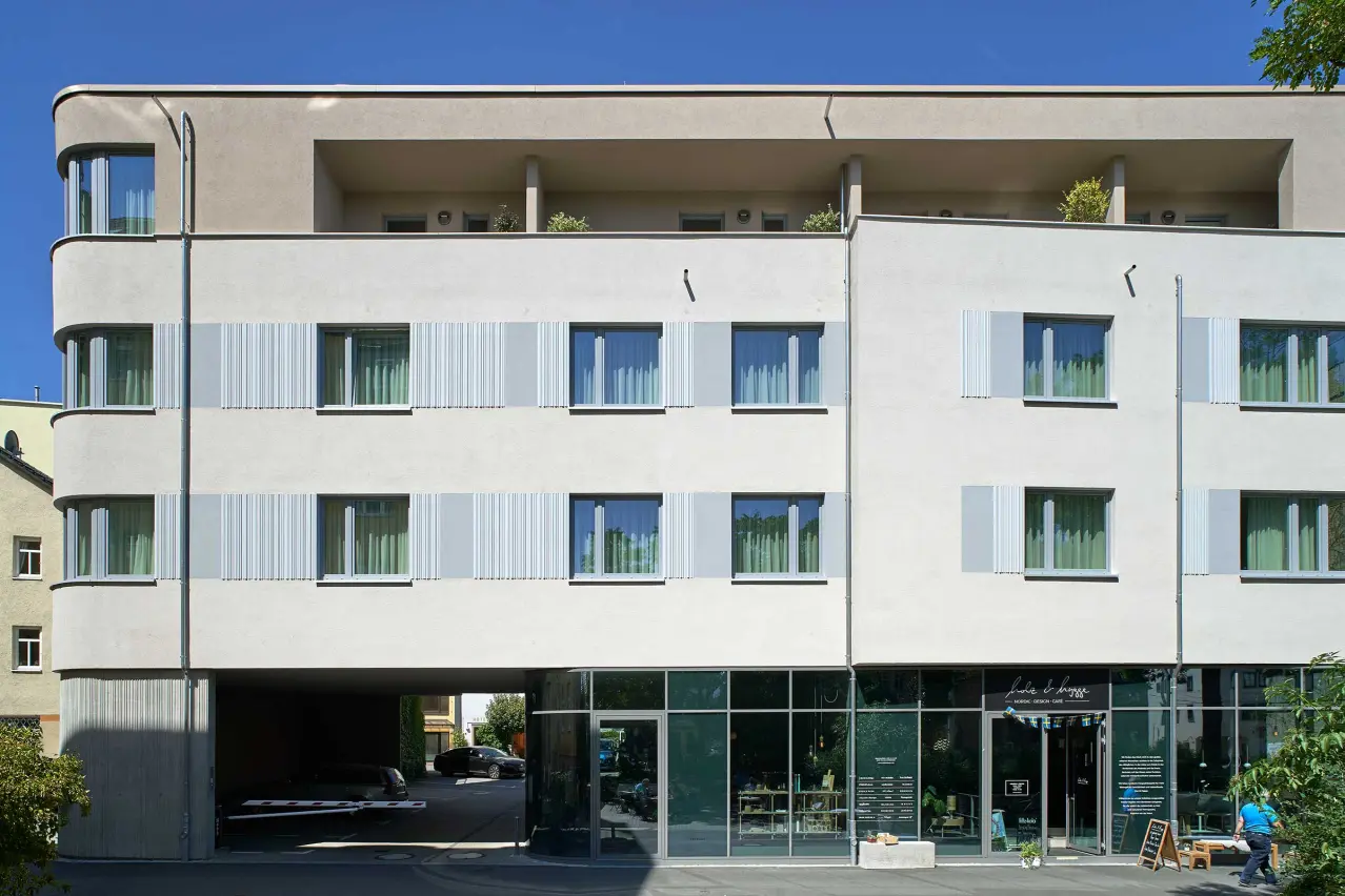 Casă de locuit cu fațadă termoizolată, finisată cu textură de tencuială StoSignature și panouri StoDeco