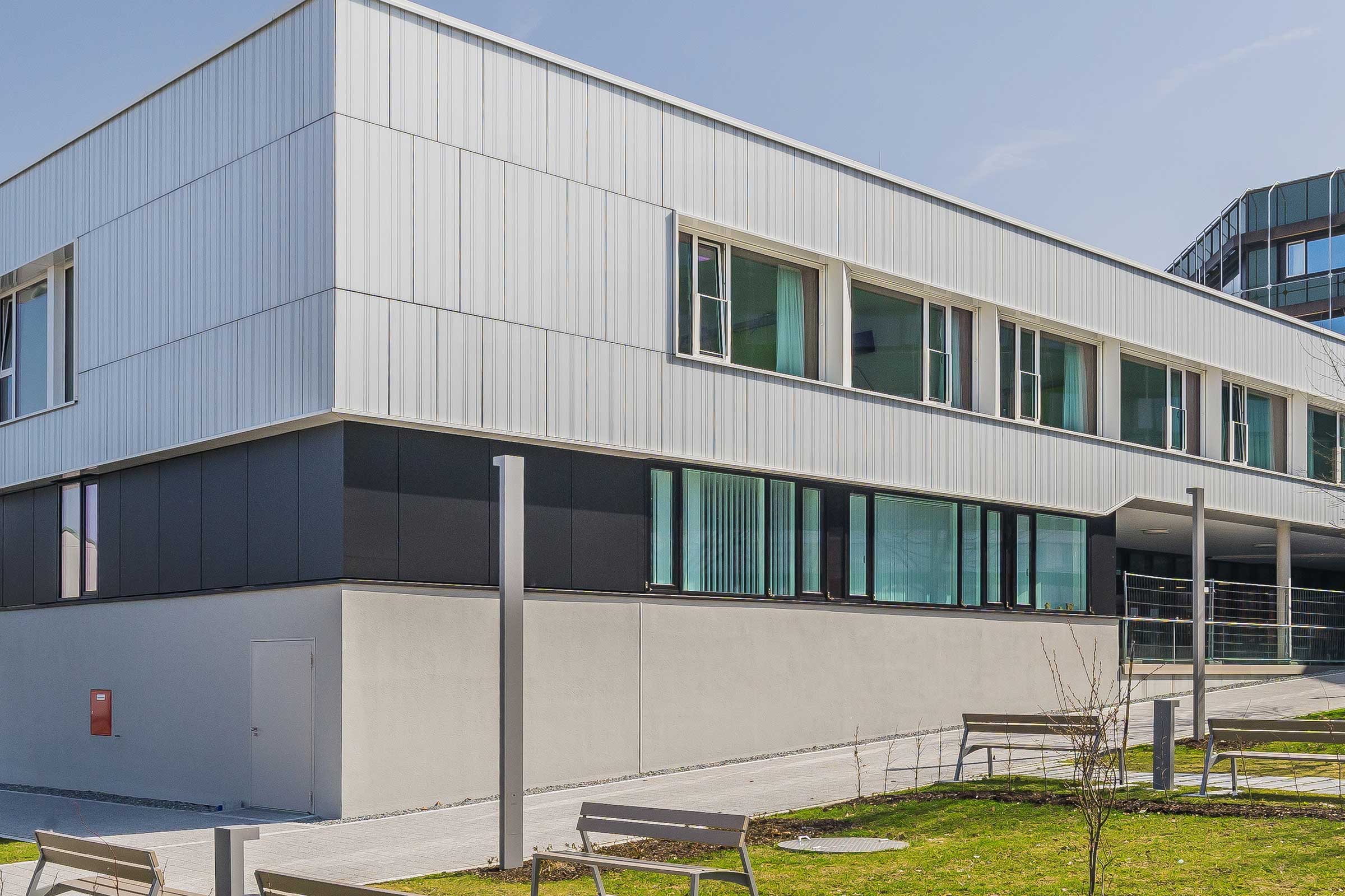 Fațadă StoVentec Glass a unui spital din Freyung, realizată cu panouri de sticlă de dimensiuni diferite
