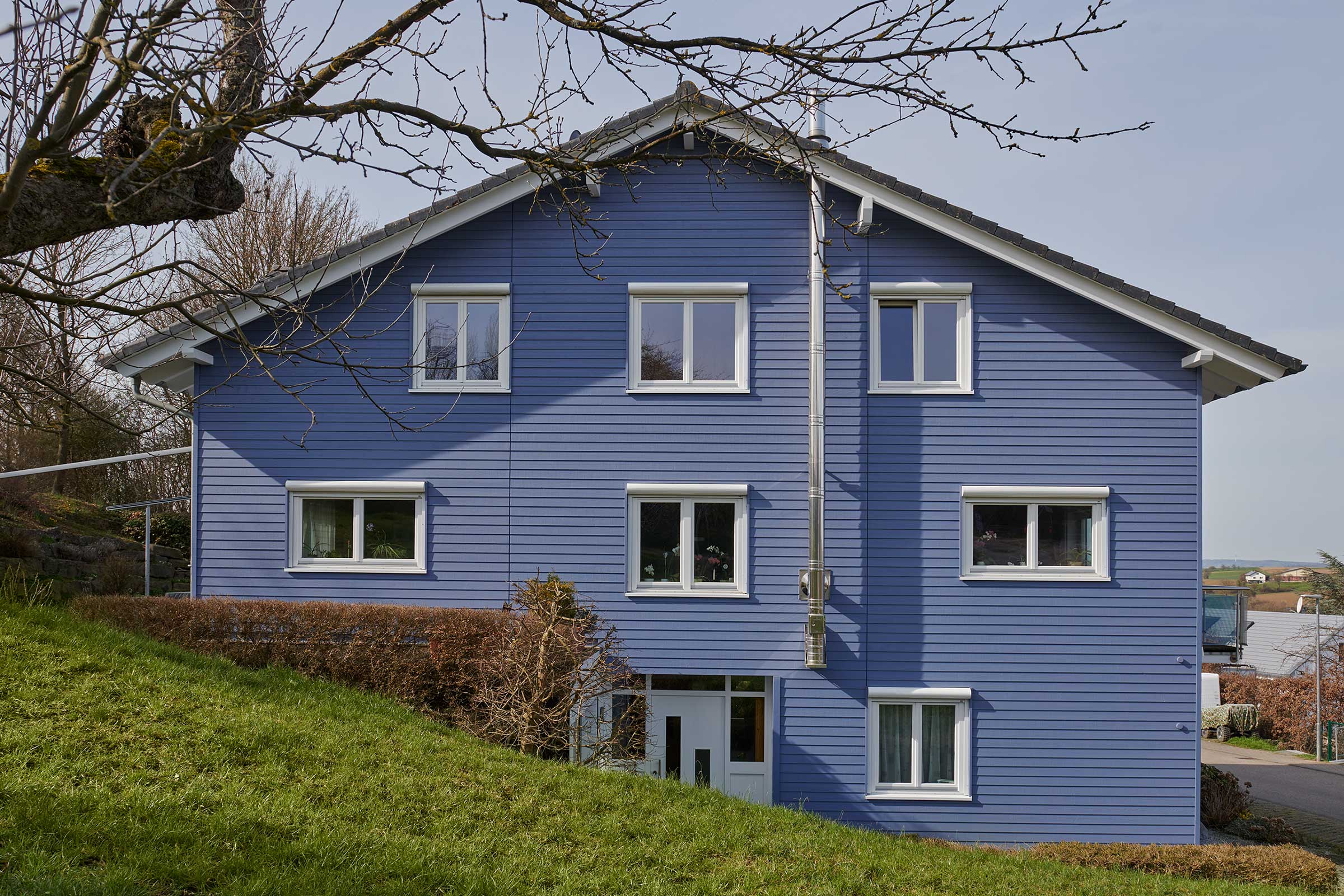 Casă unifamilială cu fațadă din lemn albastră, acoperită cu StoColor Dryonic Wood