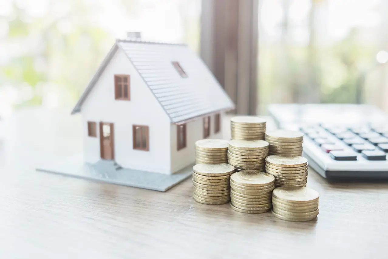 Machetă de casă, bani și calculator – termoizolarea fațadei economisește bani și energie
